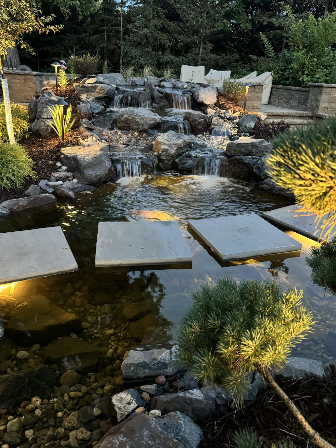 Water feature with floating stone pathway A calming water feature surrounded by a carefully crafted stone pathway, adding an element of tranquility to this beautifully landscaped garden.